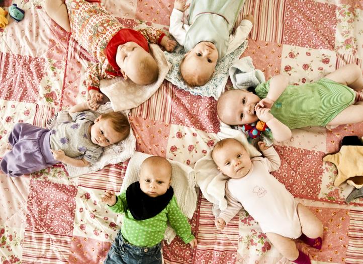 Billedet viser babyer på et tæppe